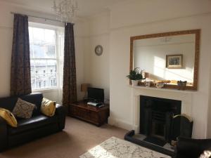 a living room with a mirror and a fireplace at Teesdale Rooms in Whitby