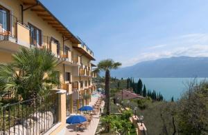 een uitzicht op een hotel met tafels en parasols bij All Inclusive Hotel Piccolo Paradiso in Toscolano Maderno