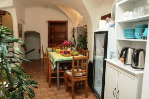 a kitchen with a table and chairs and a kitchen with a refrigerator at Mini Hotel Abraka & Apartments in Český Krumlov