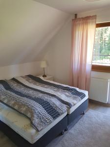 a bed sitting in a room with a window at Agroturystyka Giławy in Giławy