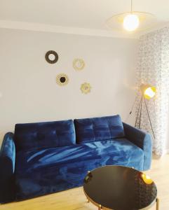 a blue couch in a living room with a table at Apartament Niebieski in Świnoujście