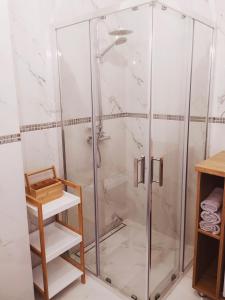 y baño con ducha y mampara de cristal. en Apartament Niebieski, en Świnoujście