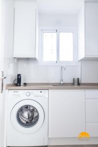 een witte keuken met een wasmachine en een wastafel bij Casa Genoves by Cadiz Time in Cádiz