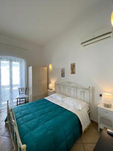 - une chambre avec un grand lit et une couverture bleue dans l'établissement B&B da Mimino e Franceschina, à Crispiano