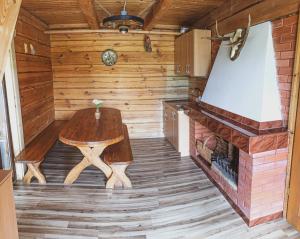 a wooden room with a table and a fireplace at Storių sodyba in Anykščiai
