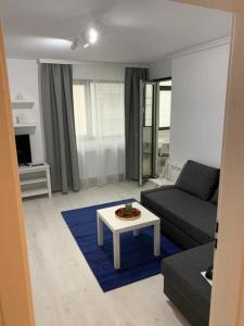 uma sala de estar com um sofá e uma mesa em Apartment Pitesti em Piteşti