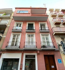 a red building with windows and balconies at Pensión Duquesa Bed & Breakfast in Granada