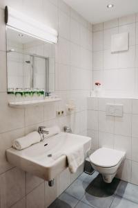 a white bathroom with a sink and a toilet at Gasthof Wunder in Gnesau Sonnleiten