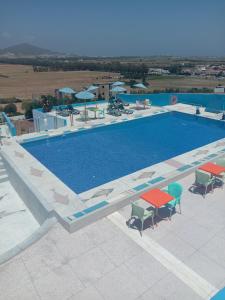 a swimming pool with tables and chairs next to it at Maliana Star in Tetouan