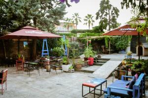 een patio met tafels, stoelen en parasols bij Hostel Durres in Durrës