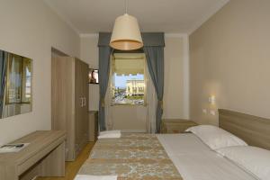 a hotel room with a bed and a lamp at Hotel La Pace in Viareggio