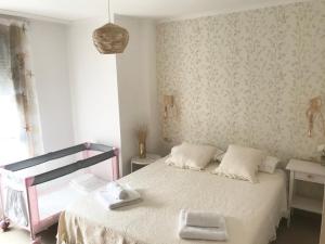 ein Schlafzimmer mit einem Bett mit weißer Bettwäsche und einer Tapete in der Unterkunft Apartamentos Trebol in Sanxenxo