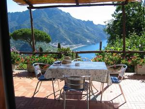 einen Tisch und Stühle mit Blick auf das Wasser in der Unterkunft Villa Casale Ravello Residence in Ravello