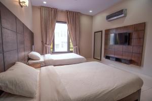 pokój hotelowy z 2 łóżkami i telewizorem w obiekcie Hillside Homes w mieście Karaczi