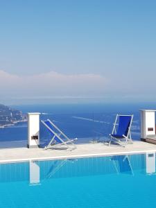 zwei Stühle am Pool in der Unterkunft Villa Casale Ravello Residence in Ravello