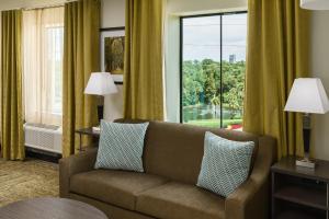 salon z kanapą i dużym oknem w obiekcie Candlewood Suites - Orlando - Lake Buena Vista, an IHG Hotel w Orlando