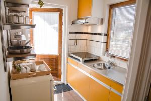 una pequeña cocina con fregadero y ventana en Emma's beach house en Katwijk aan Zee