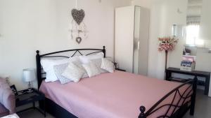 sypialnia z łóżkiem z różową pościelą i białymi poduszkami w obiekcie Studio Al Ponto w Rovinj