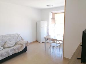 コラレホにあるApartamentos lidiaのベッドルーム(ダイニングルームテーブル、白い冷蔵庫付)