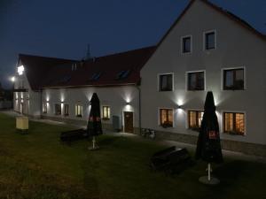 a large white house with umbrellas in front of it at Zajazd Zachęta in Kamienna Góra