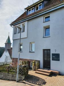 a white house with a street light in front of it at Ferienwohnung Schwarzwaldblick in Unterreichenbach