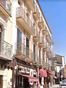 un edificio con balcones al lado de una calle en Hostal Plaza en Segovia