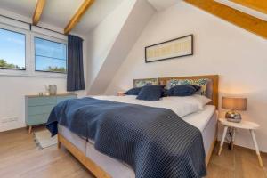 Un dormitorio con una cama grande con una manta azul. en Suite Windrose, en Zingst