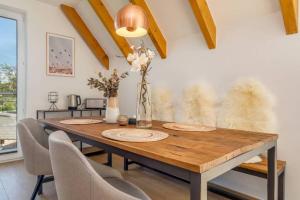 una mesa de comedor con sillas y un jarrón de flores en Suite Windrose, en Zingst