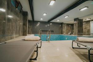 a swimming pool with two benches in a room at 216 Castle Hotel in Gebze