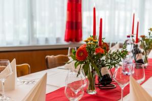 einen Tisch mit einer Vase aus Blumen und Weinflaschen in der Unterkunft Hotel du Pont in Gampel
