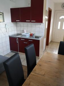a kitchen with red cabinets and a table and chairs at Apartment Damijan in Bled