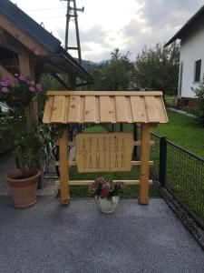 un banco de madera con un cartel que lee el patio trasero Davis en Apartment Damijan, en Bled