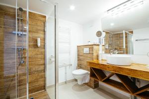a bathroom with a sink and a toilet and a shower at Buchenland Hotel in Câmpulung Moldovenesc