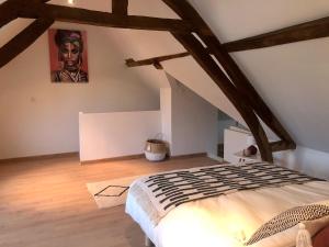 ein Schlafzimmer mit einem Bett und einem Wandgemälde in der Unterkunft Le charme et l’original in Ailly-le-Haut-Clocher