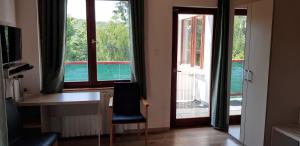 マートラゼンティムレにあるMátraszentimre Panzióのデスク、椅子、窓が備わる客室です。