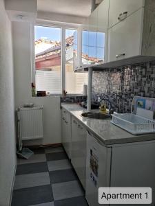 cocina con armarios blancos y suelo de baldosa en Apartments Doris, en Kruševo