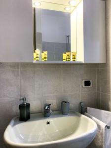 een witte wastafel in een badkamer met een spiegel bij Appartamento rosada in Stresa