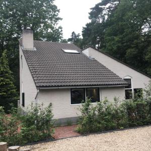 a white house with a black roof at Huusje21 in Nunspeet