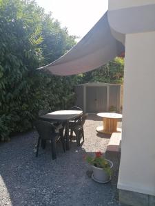 a patio with a table and chairs and a tent at La gravière in Saint-Geours-de-Maremne