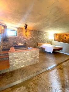 um quarto com uma banheira e uma parede de pedra em Mondo Pazzo em Rota