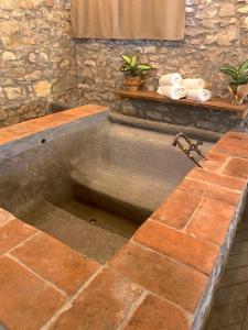uma banheira de pedra com um lavatório na casa de banho em Mondo Pazzo em Rota