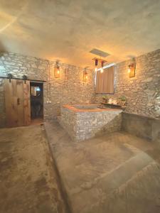 uma casa de banho com uma banheira numa parede de pedra em Mondo Pazzo em Rota