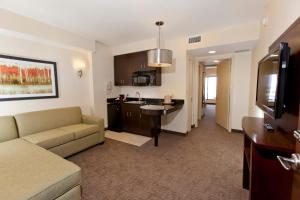 una sala de estar con sofá y una cocina en una habitación de hotel en Plaza Suites On International Drive Near Universal Studios en Orlando
