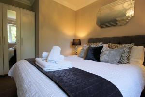 a bedroom with a large bed with towels on it at Riverbank in Callander