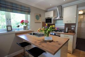 a kitchen with a counter with a vase of flowers on it at Riverbank in Callander