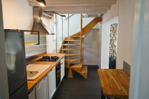 eine kleine Küche mit einer Treppe in einem winzigen Haus in der Unterkunft La Maison Des Artistes in Tourrette-Levens