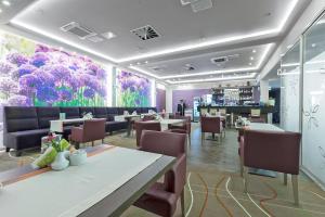 un restaurante con mesas y sillas y un mural de flores en Hotel Olivia Medical SPA, en Skomielna Czarna