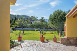 a courtyard with potted plants and a green field at Villa Vilar by Sealand Villas in El Port