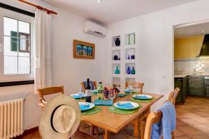 uma cozinha e sala de jantar com uma mesa de madeira e cadeiras em Ca'n toni Villa, Cala Galdana em Ferreries