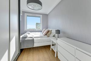 mała sypialnia z łóżkiem i oknem w obiekcie Comfort Apartments Wyspiańskiego w mieście Gdynia